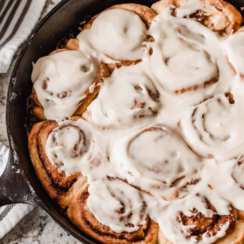 Cinnamon rolls arranged in a cast iron pan.
